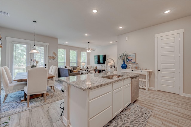 kitchen with recessed lighting, a sink, visible vents, white cabinets, and open floor plan