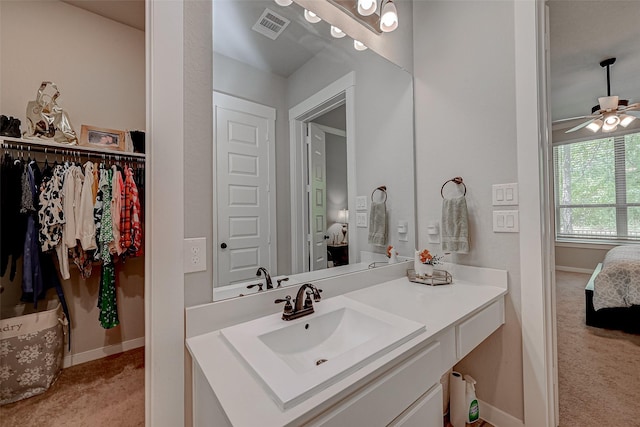 ensuite bathroom with visible vents, a ceiling fan, vanity, ensuite bath, and baseboards