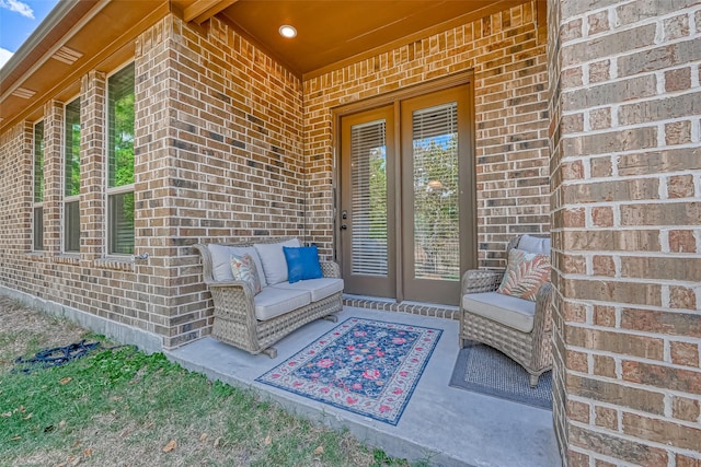 doorway to property featuring brick siding and outdoor lounge area