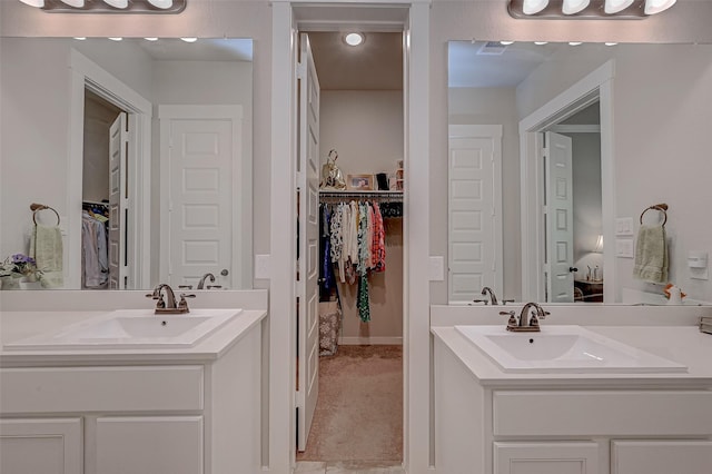 full bathroom featuring visible vents, two vanities, and a sink