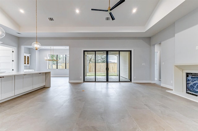 unfurnished living room featuring recessed lighting, a raised ceiling, visible vents, and baseboards