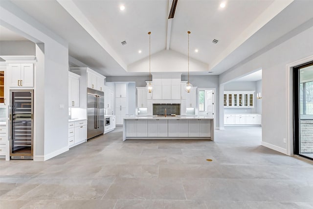 kitchen with wine cooler, tasteful backsplash, light countertops, stainless steel built in fridge, and white cabinetry