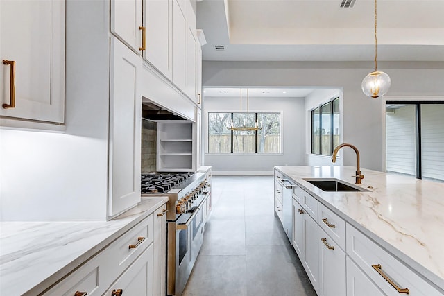 kitchen with pendant lighting, a sink, white cabinetry, and double oven range