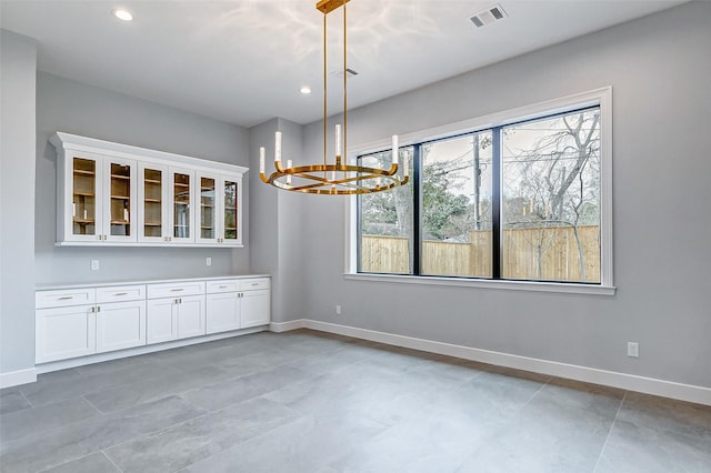 unfurnished dining area with recessed lighting, visible vents, baseboards, and an inviting chandelier