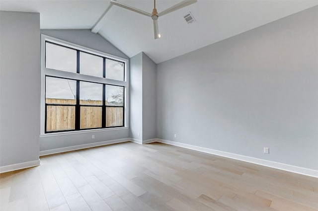 spare room featuring light wood finished floors, baseboards, visible vents, and beamed ceiling