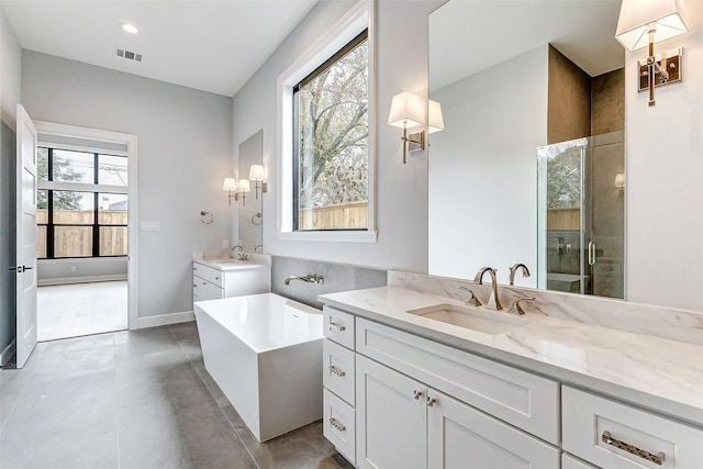 full bath featuring two vanities, visible vents, a sink, and tiled shower