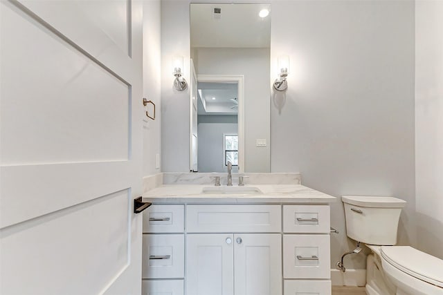 bathroom with visible vents, vanity, and toilet