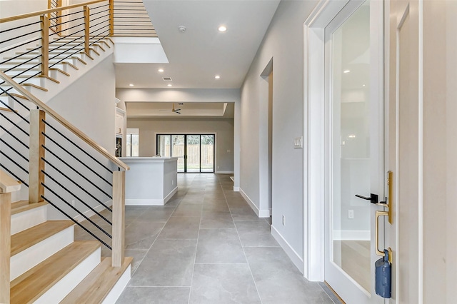 foyer entrance featuring light tile patterned flooring, stairs, baseboards, and recessed lighting