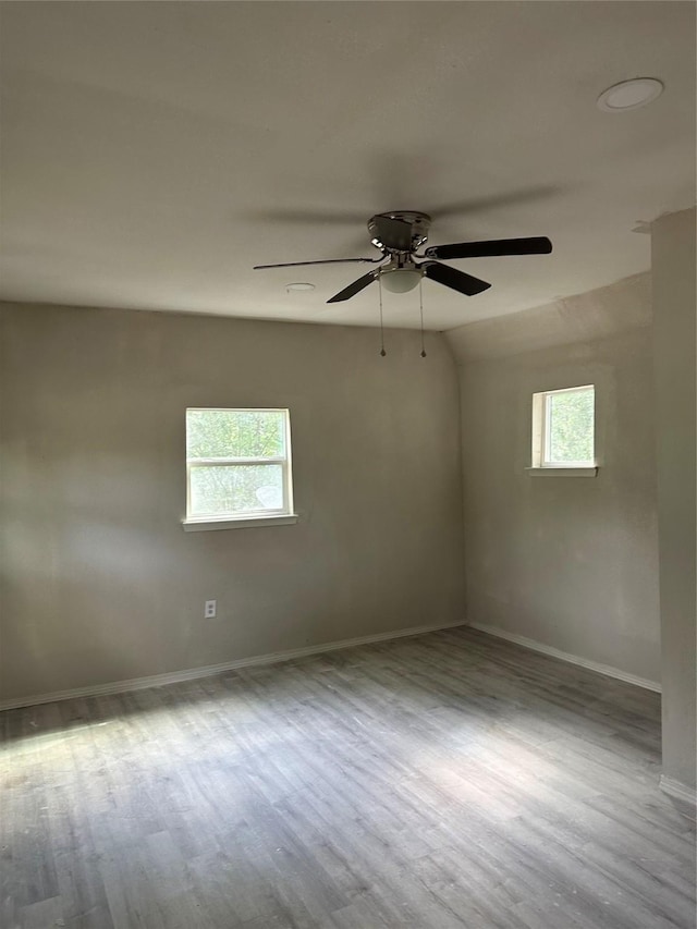 empty room with a ceiling fan, baseboards, and wood finished floors