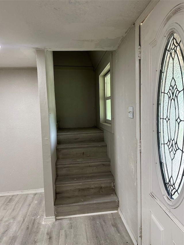 staircase with baseboards and wood finished floors