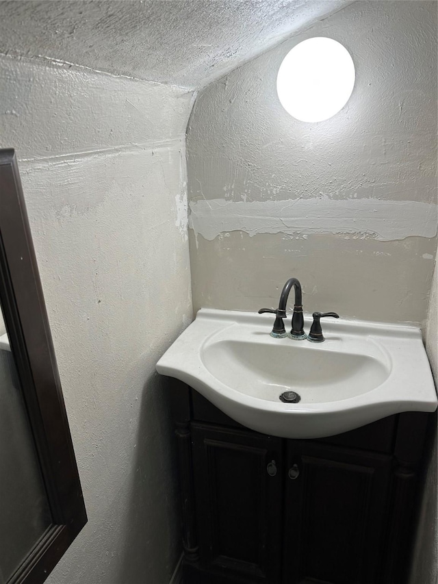 bathroom featuring a textured wall and vanity