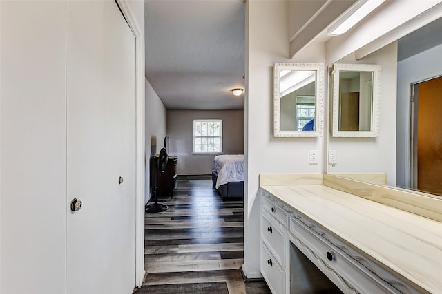 bathroom with vanity, ensuite bath, wood finished floors, and baseboards