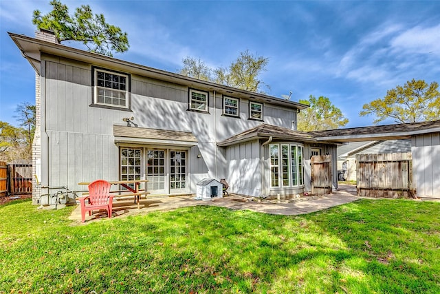 rear view of property with a yard, fence, a chimney, and a patio area