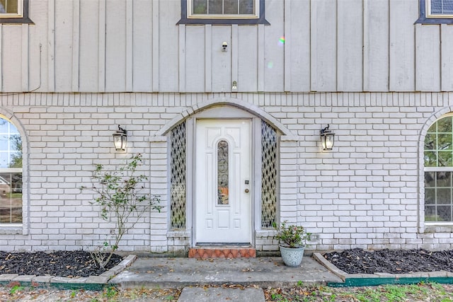 view of exterior entry featuring brick siding