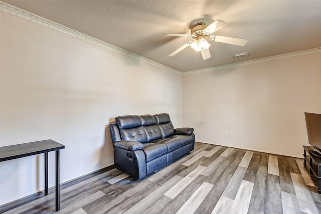 sitting room with wood finished floors, a ceiling fan, visible vents, and ornamental molding