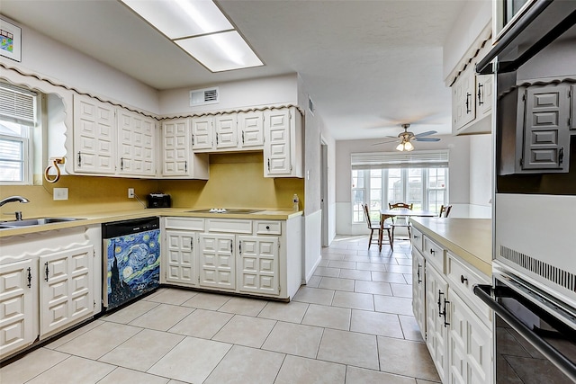 kitchen featuring visible vents, light countertops, white cabinets, black appliances, and a sink