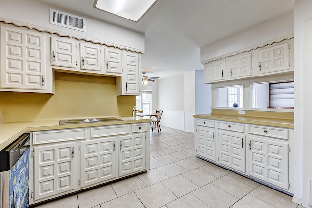 kitchen with visible vents, black electric stovetop, light countertops, wainscoting, and stainless steel dishwasher