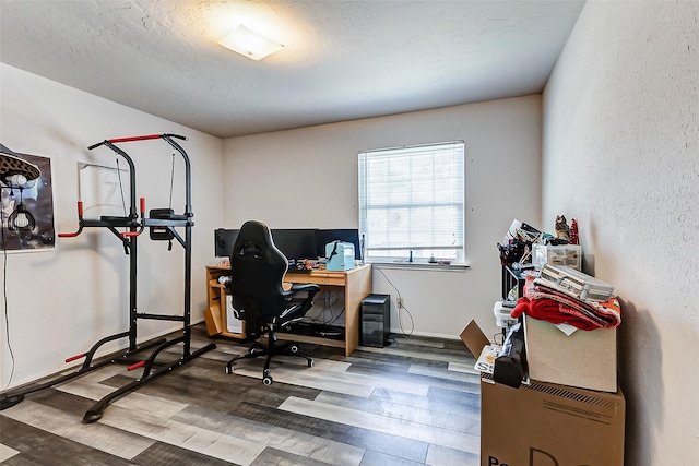 office space featuring a textured ceiling, baseboards, and wood finished floors