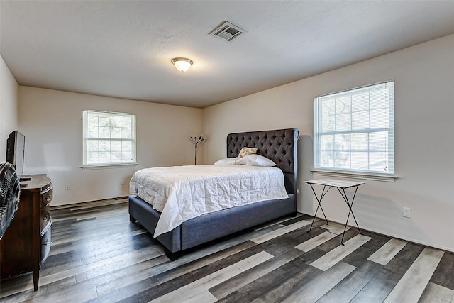 bedroom featuring wood finished floors and visible vents