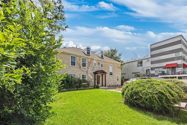 view of front facade with a front yard and brick siding