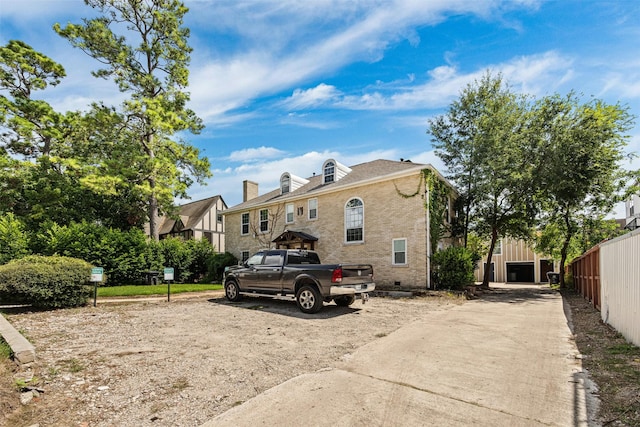 view of front of home with brick siding, crawl space, and fence