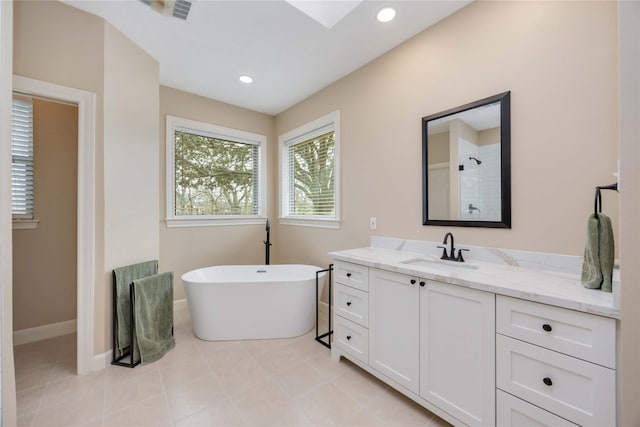 bathroom with vanity, recessed lighting, a tile shower, a freestanding bath, and tile patterned flooring