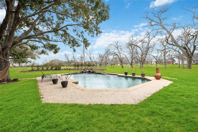 view of swimming pool with a yard