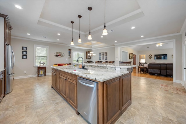 kitchen featuring ornamental molding, appliances with stainless steel finishes, a raised ceiling, and a sink