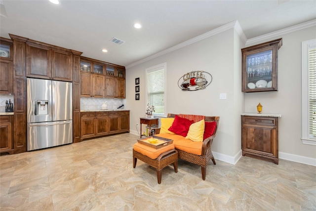 living area featuring crown molding, baseboards, and visible vents