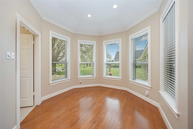 empty room with recessed lighting, baseboards, ornamental molding, and light wood finished floors