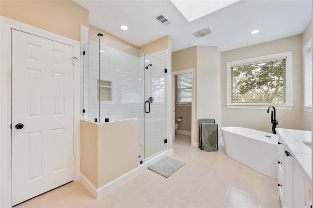 bathroom with visible vents, toilet, a stall shower, tile patterned floors, and a soaking tub