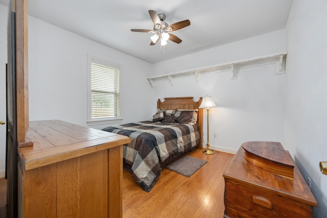 bedroom with baseboards, light wood-style floors, and a ceiling fan