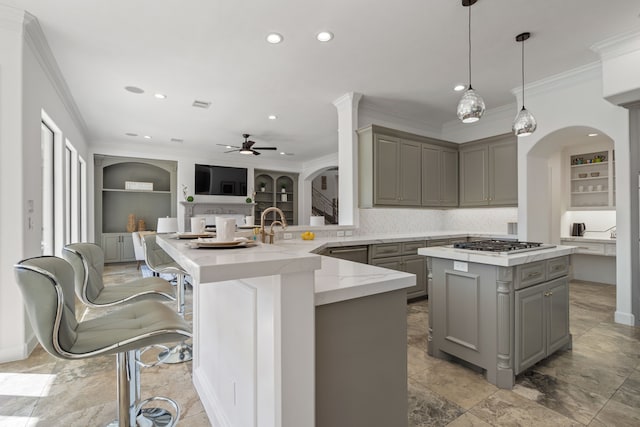 kitchen with gray cabinets, built in features, stainless steel gas stovetop, crown molding, and light stone countertops