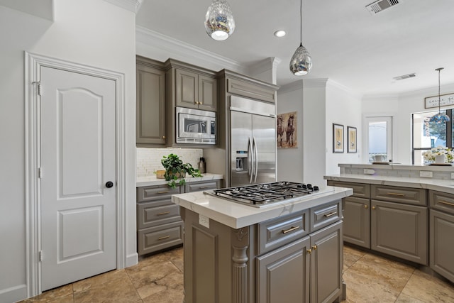 kitchen with visible vents, a kitchen island, gray cabinets, ornamental molding, and built in appliances