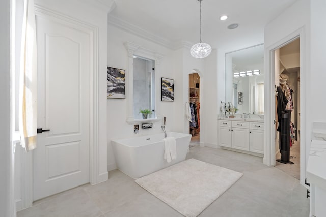 full bathroom featuring a walk in closet, recessed lighting, baseboards, a soaking tub, and vanity