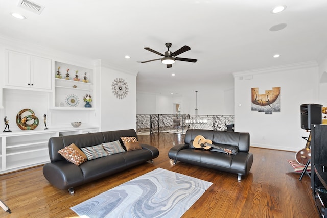 living room featuring visible vents, crown molding, built in features, recessed lighting, and wood finished floors