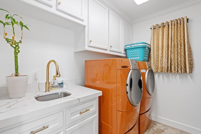 laundry area with baseboards, ornamental molding, cabinet space, independent washer and dryer, and a sink