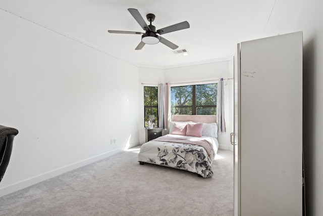 bedroom with visible vents, baseboards, carpet, ornamental molding, and a ceiling fan