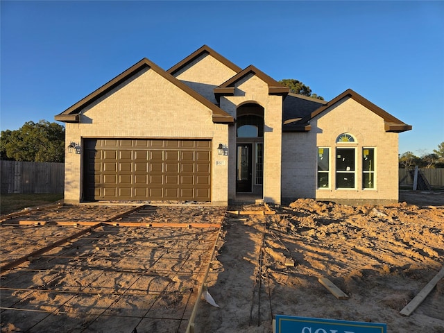 single story home with an attached garage, fence, and brick siding