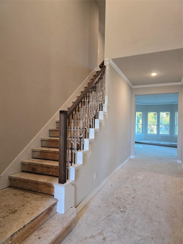 staircase with baseboards, a high ceiling, and crown molding