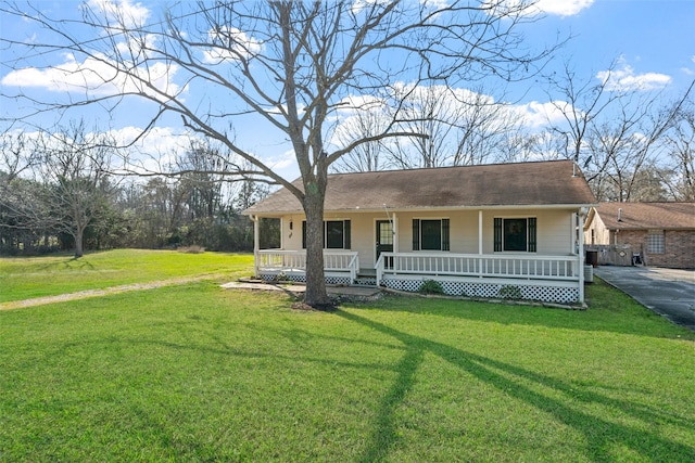 view of front facade featuring driveway, a porch, and a front yard