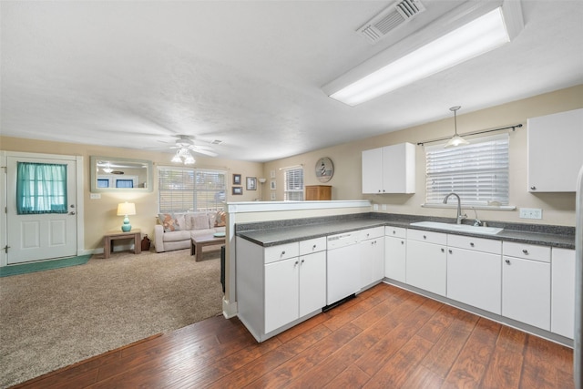 kitchen featuring dark countertops, visible vents, open floor plan, a sink, and white dishwasher