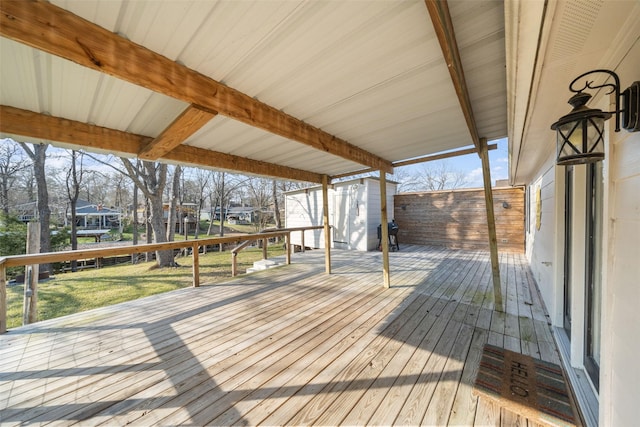 wooden deck featuring a storage shed and an outdoor structure