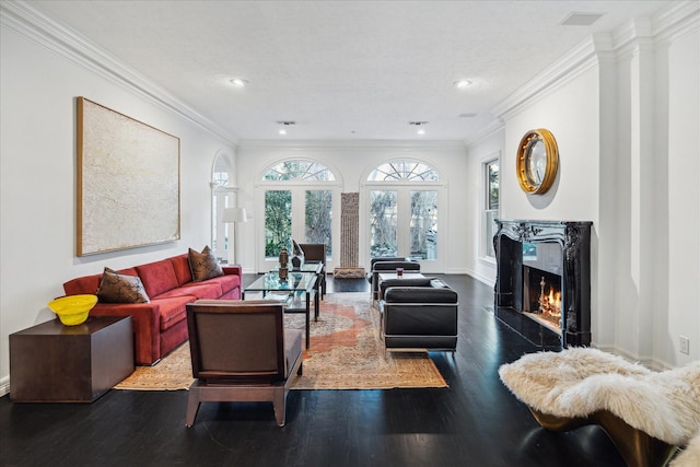 living area featuring baseboards, a fireplace, wood finished floors, and crown molding