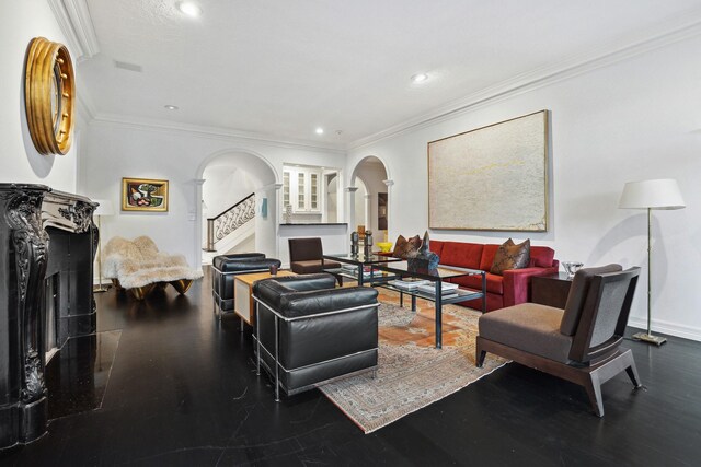 living area with stairway, crown molding, arched walkways, and wood finished floors