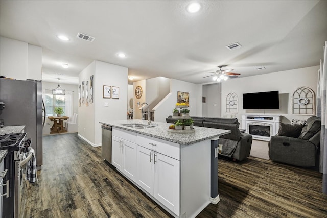 kitchen featuring stainless steel appliances, a sink, visible vents, dark wood-style floors, and an island with sink