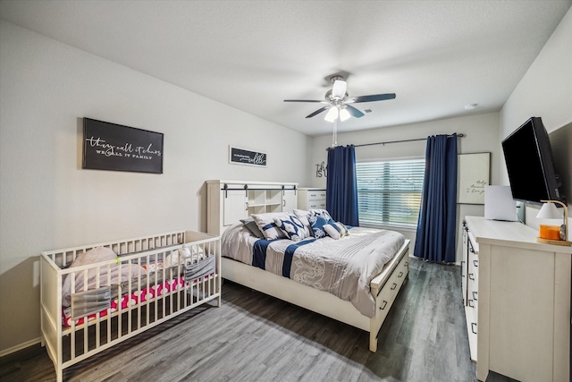 bedroom featuring a ceiling fan, baseboards, and wood finished floors