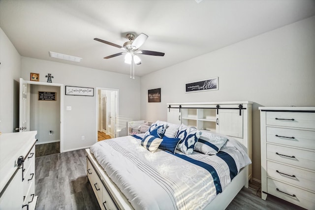 bedroom featuring dark wood-style floors, ensuite bath, visible vents, and baseboards