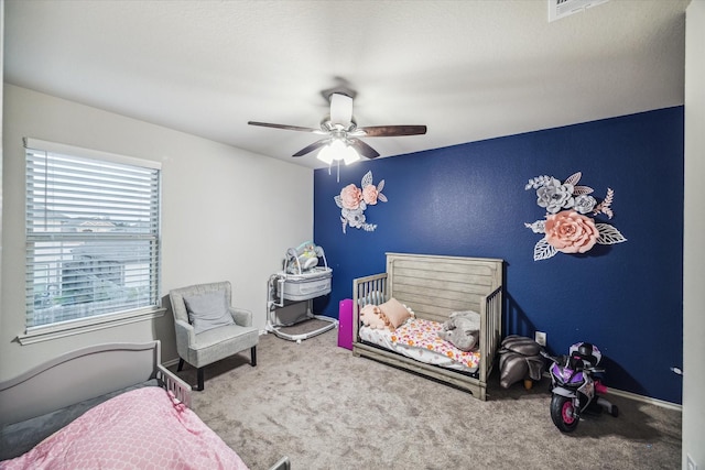 carpeted bedroom with a ceiling fan and visible vents