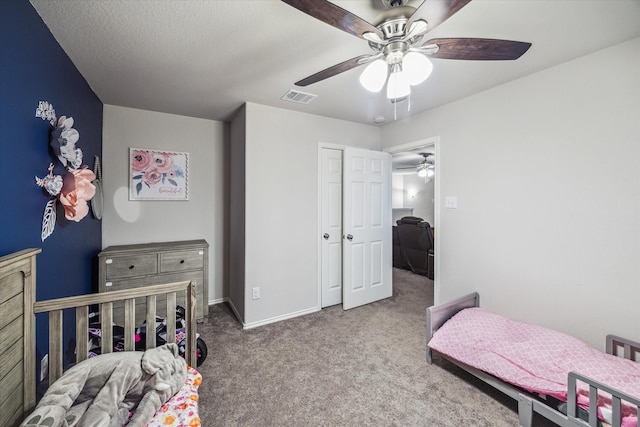 carpeted bedroom with baseboards, visible vents, and a ceiling fan